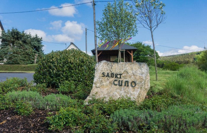 Ein Stein weist auf den Ortsbereich hin. Im Hintergrund der provisorische Maibaum 2020 - die Corona-Krise hat das Aufstellen eines großen Baumes nicht möglich gemacht.